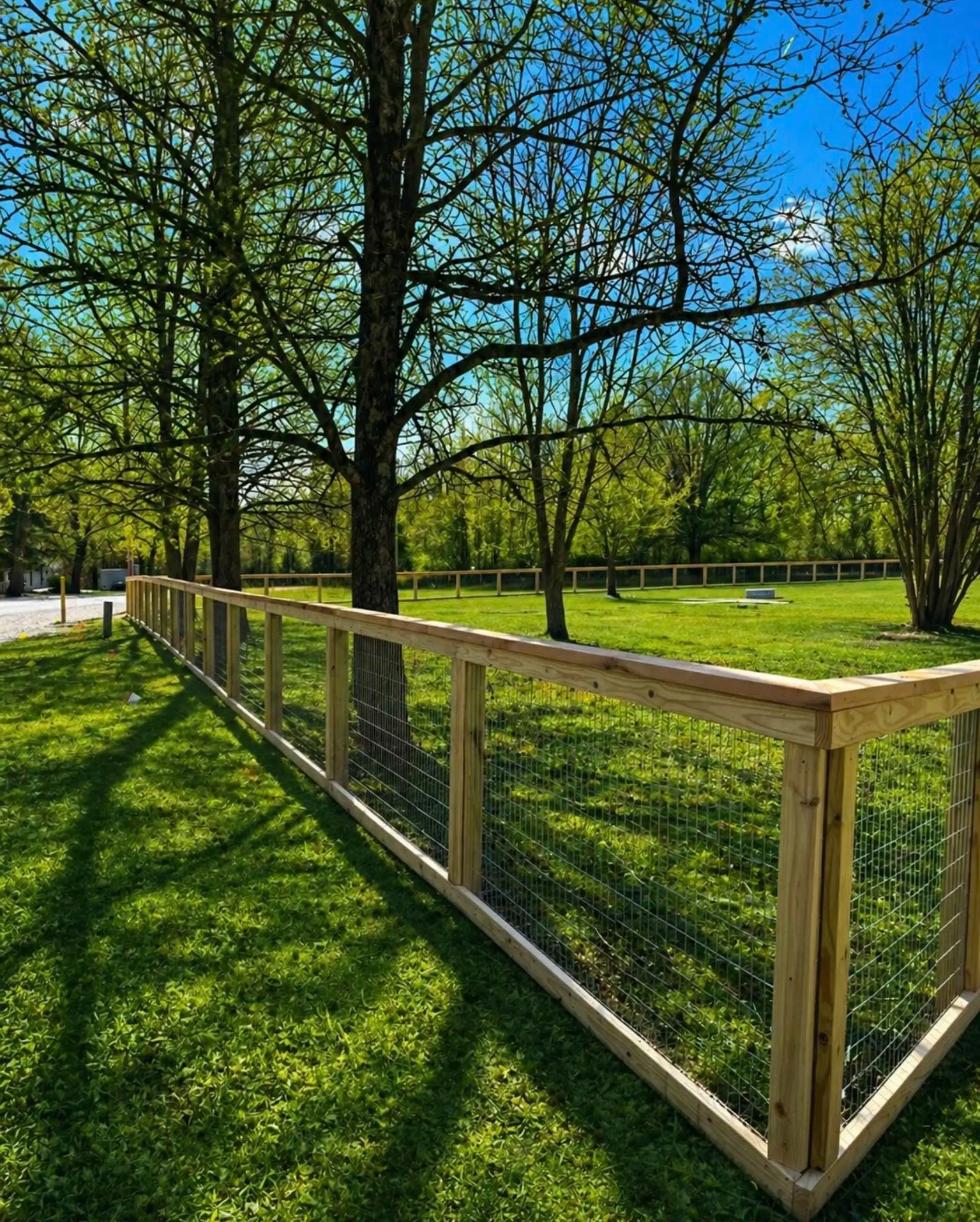 Pine frame and wire mesh fence with a cedar cap, designed to keep pets in while maintaining an open rural view.